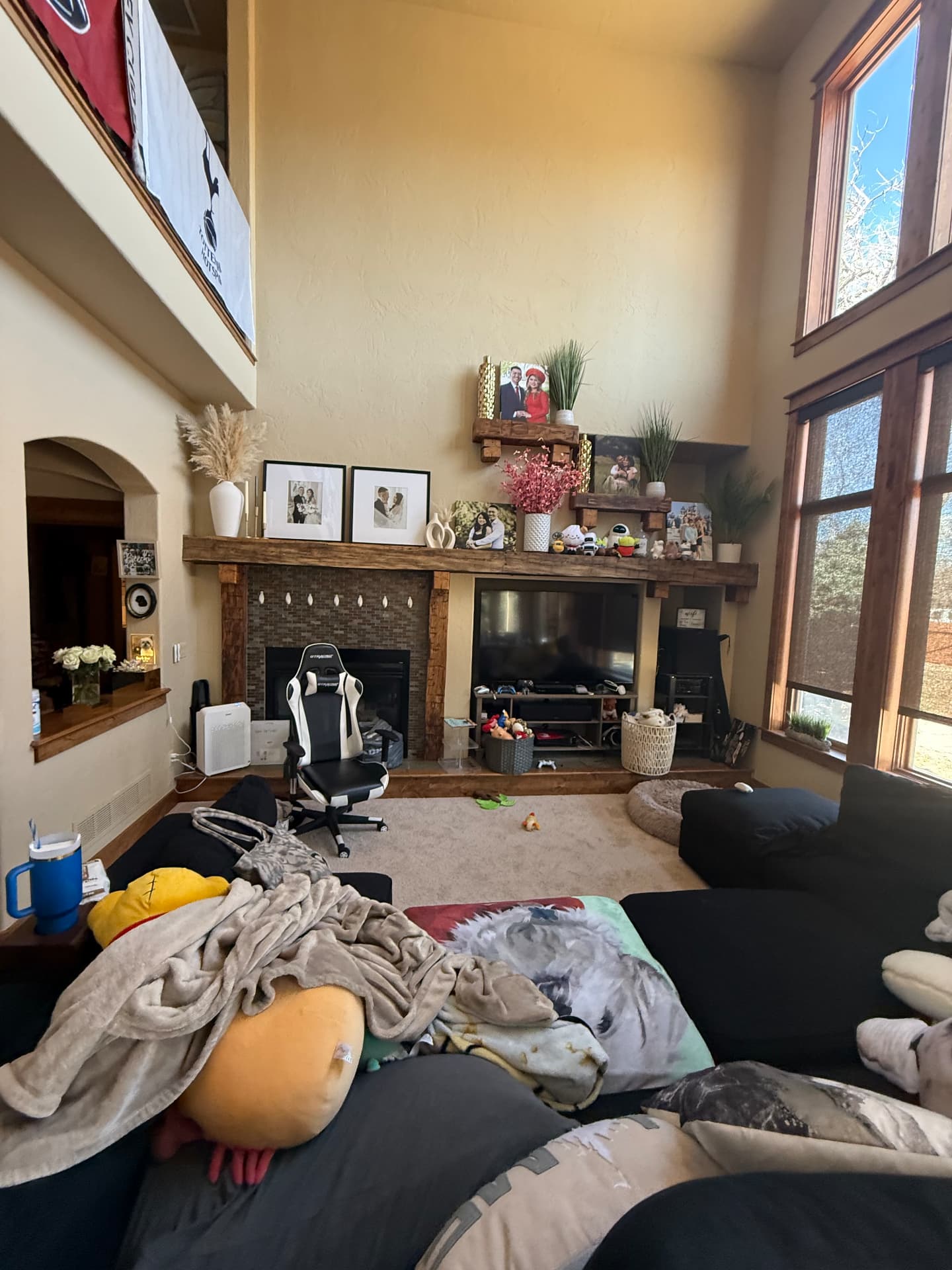 Two-story living room with old tile fireplace and rustic mantel before remodel