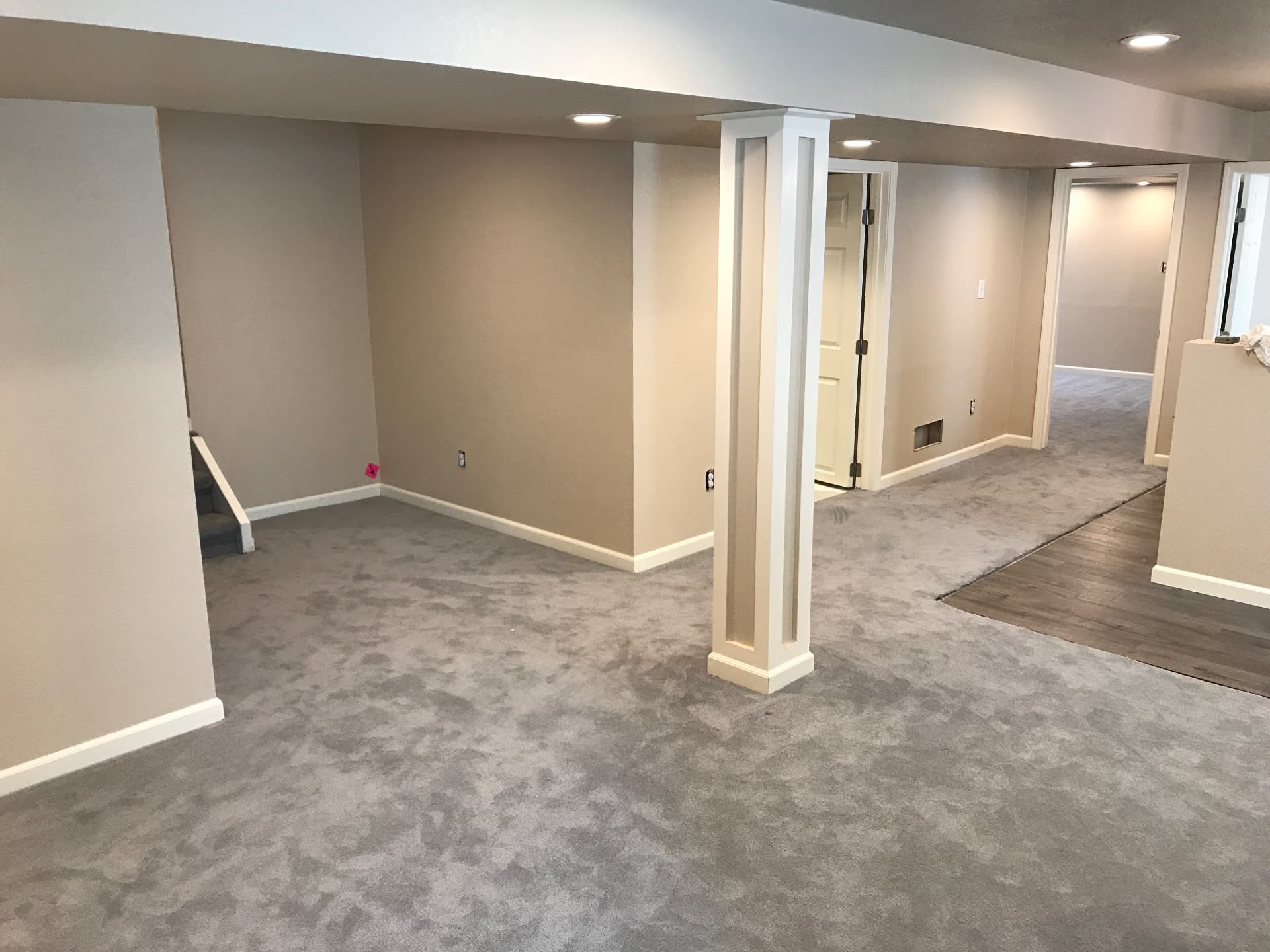 Finished basement with gray carpet, craftsman column, and recessed lighting