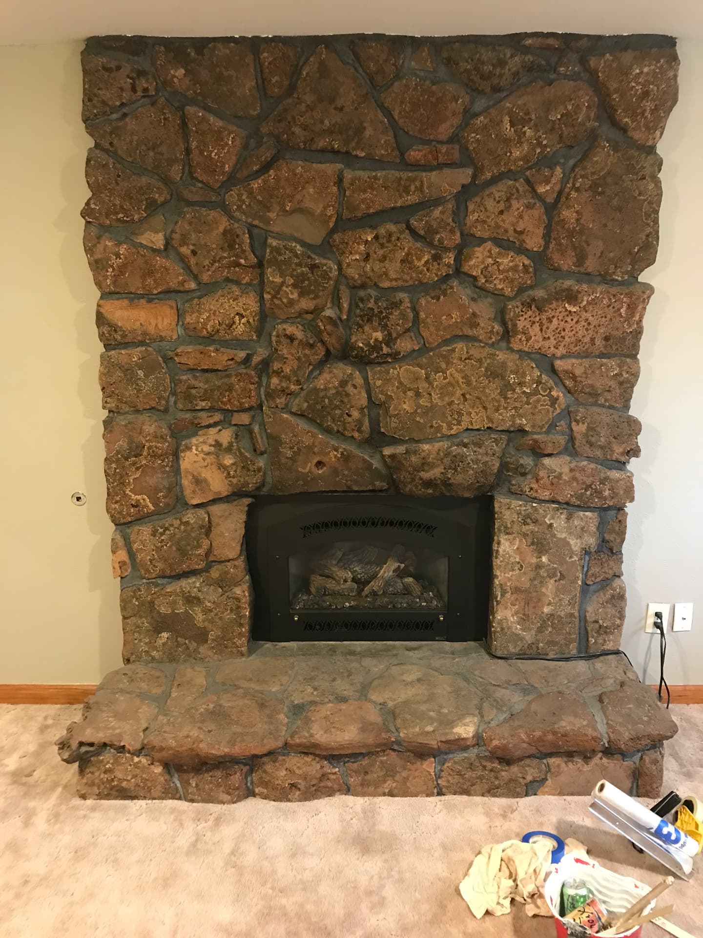 Old moss rock fireplace with raised hearth before remodel