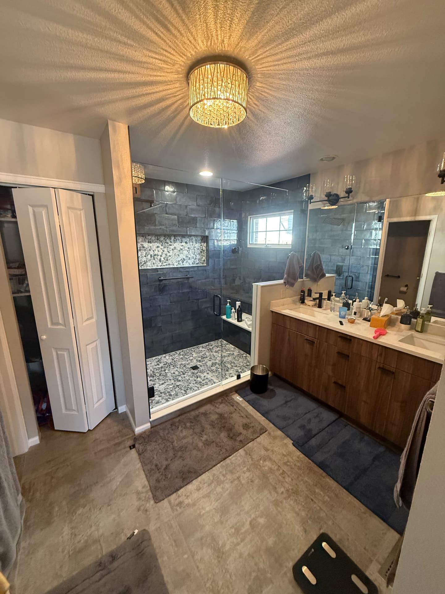 Finished master bathroom with glass shower, slate tile, and walnut double vanity