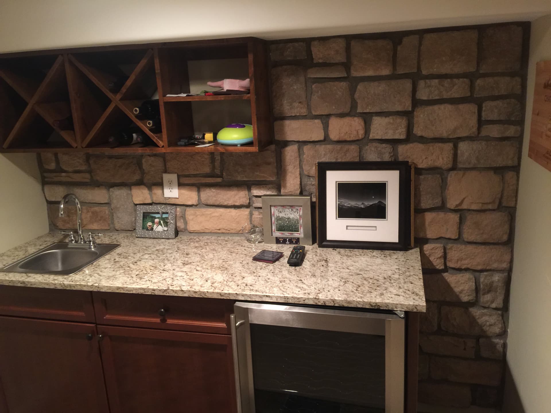 Wet bar with stacked stone wall and custom wood wine rack
