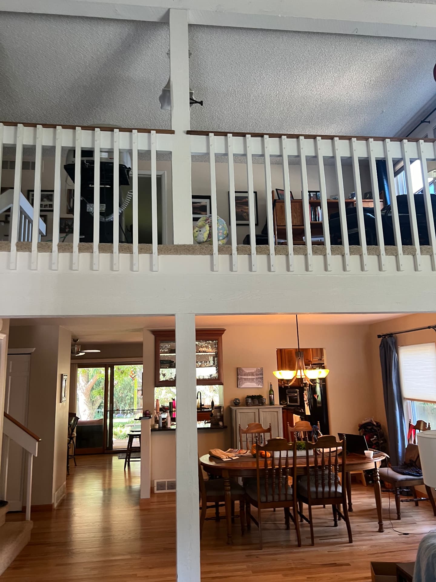 Loft with white wood spindle railing before remodel