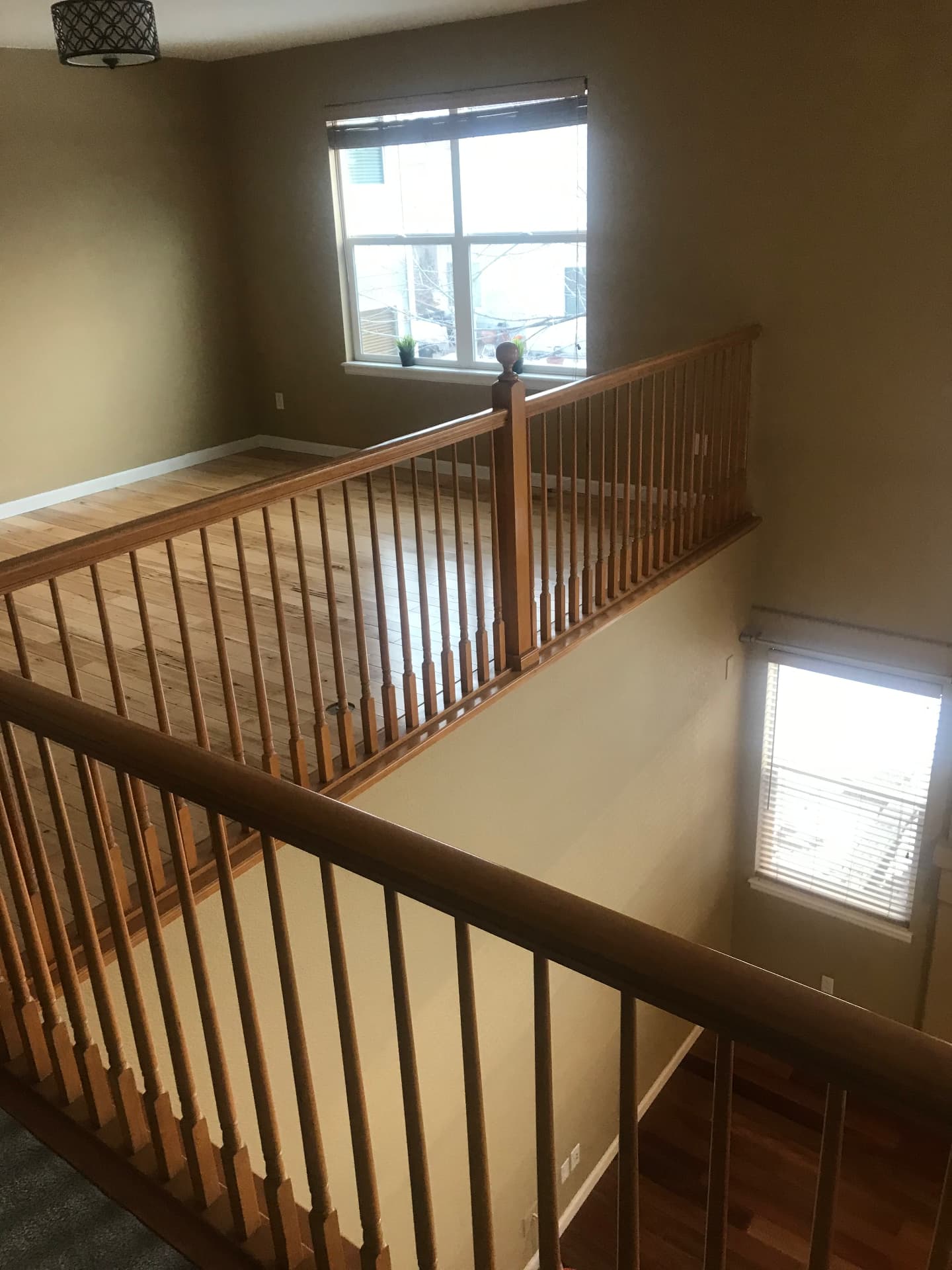 Open loft with honey oak railing and balusters before conversion to a bedroom