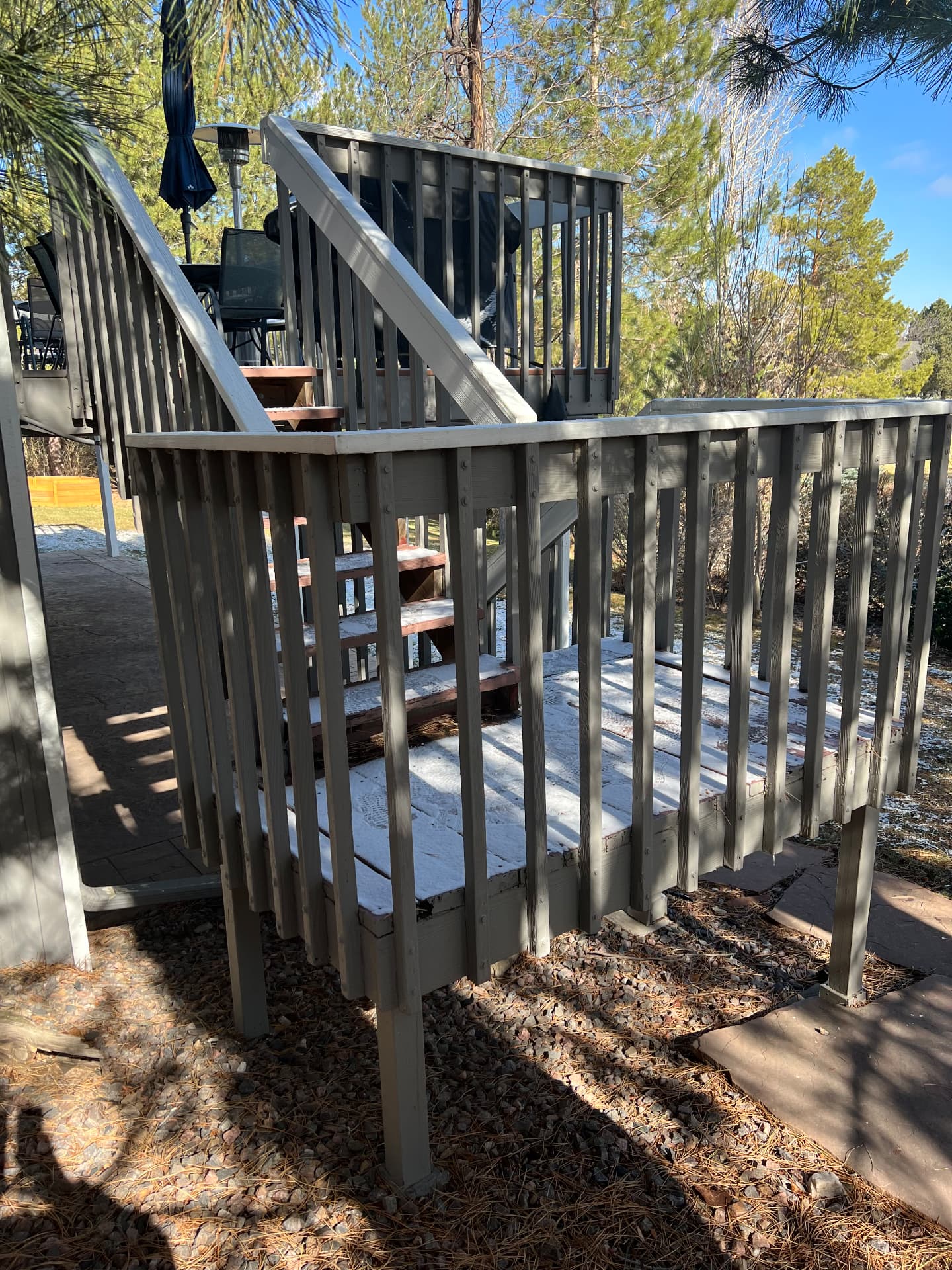 Old wooden deck landing with peeling gray paint and worn stairs