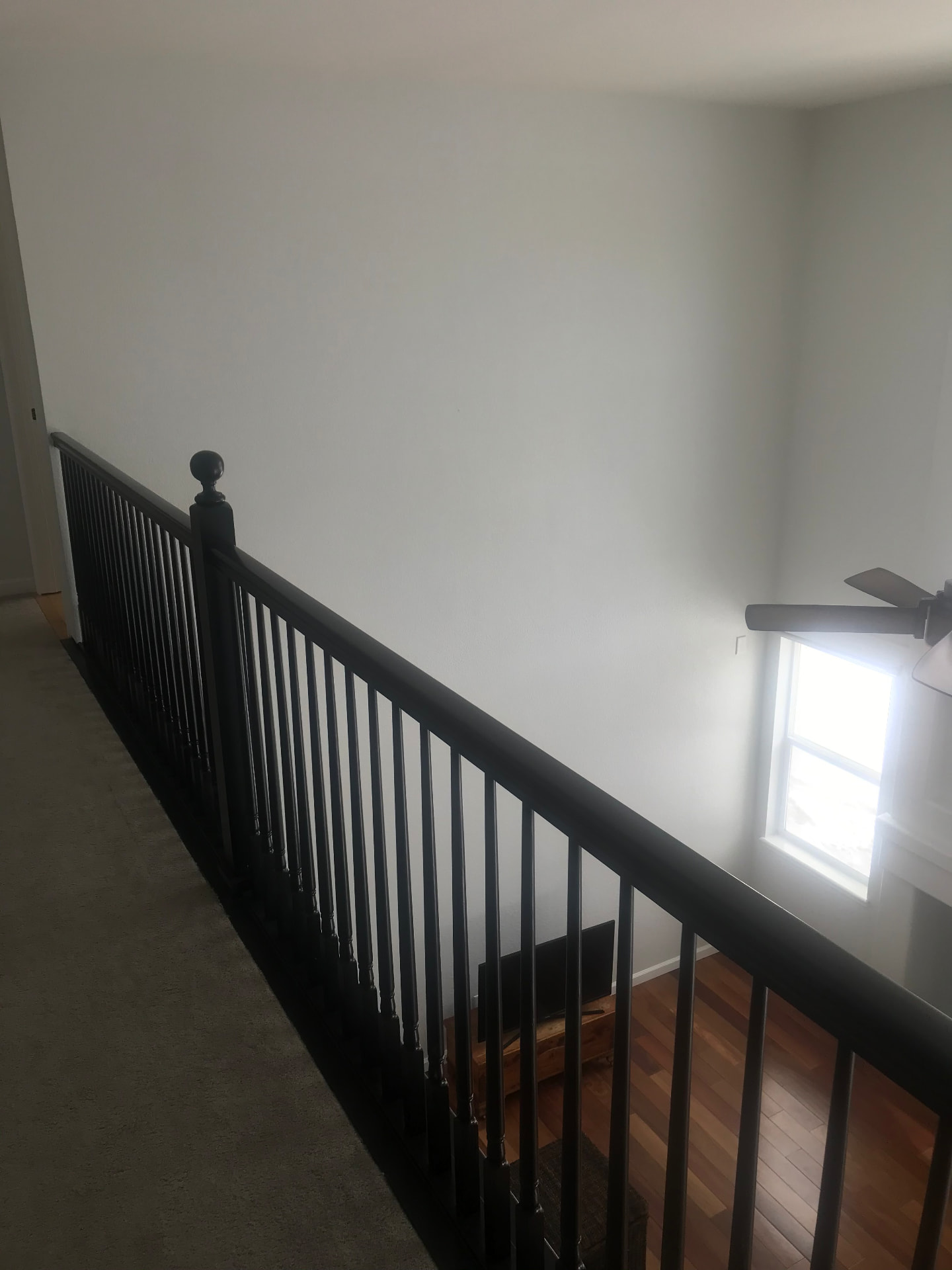 Loft converted to a bedroom with the railing refinished in dark espresso