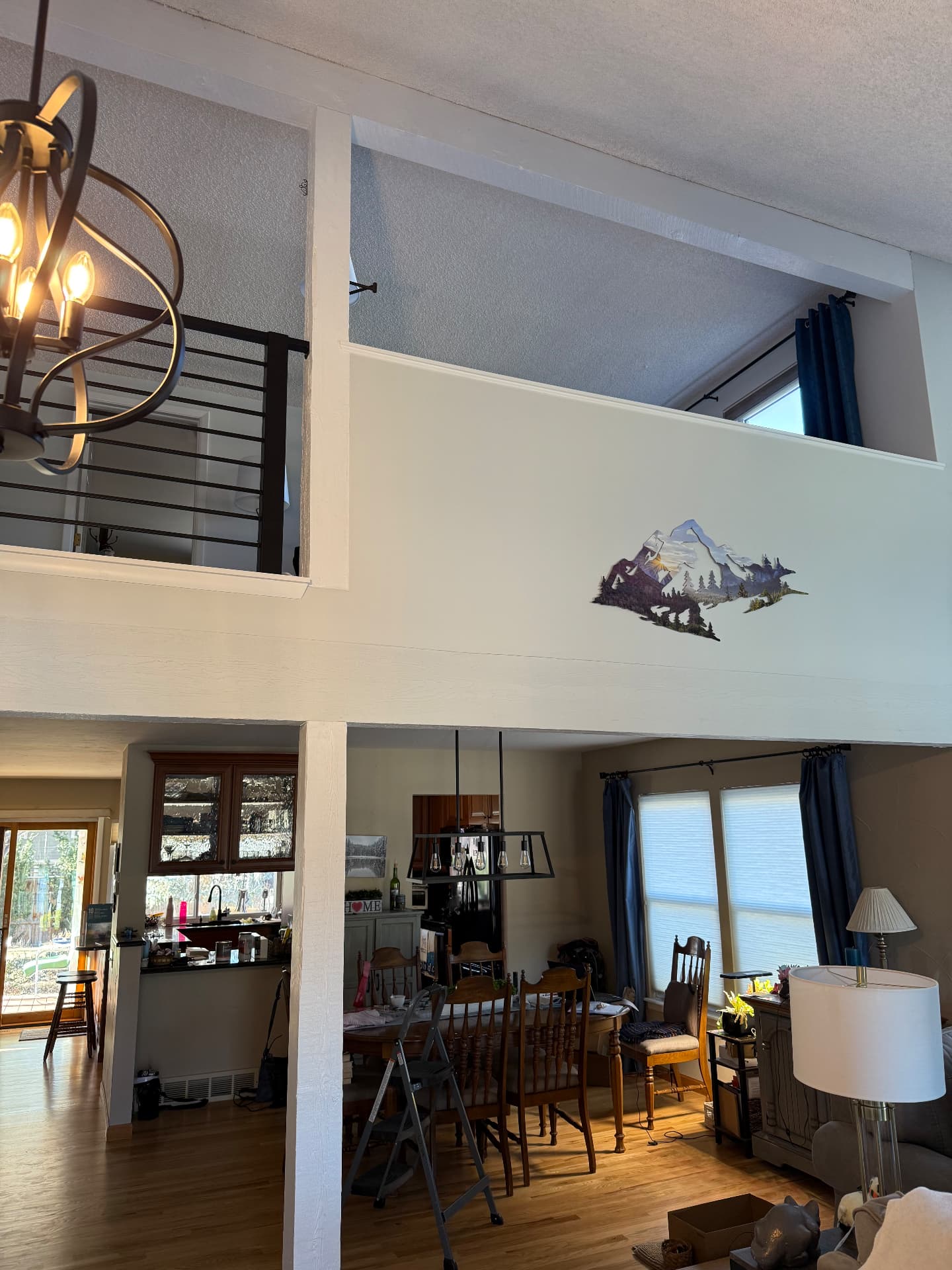 Loft with drywall half wall and horizontal iron railing after remodel